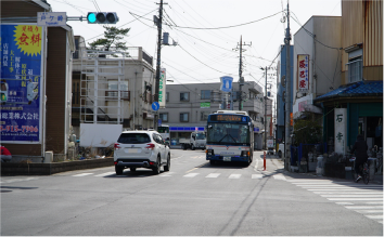 「戸ヶ崎」の表示板が付けられた信号機が設置され、バスや車が行きかっている交差点のカラー写真