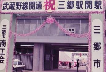 駅構内の入り口に装飾され「武蔵野線開通 祝 三郷駅開駅」と書かれたお祝いの看板が設置された三郷駅の写真