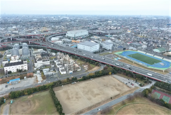令和3年（2021年）に上空から撮影された、三郷インターチェンジに隣接し長方形の人工芝を青の走路が囲む三郷市陸上競技場とその周辺に立ち並ぶ建物や運動場の写真