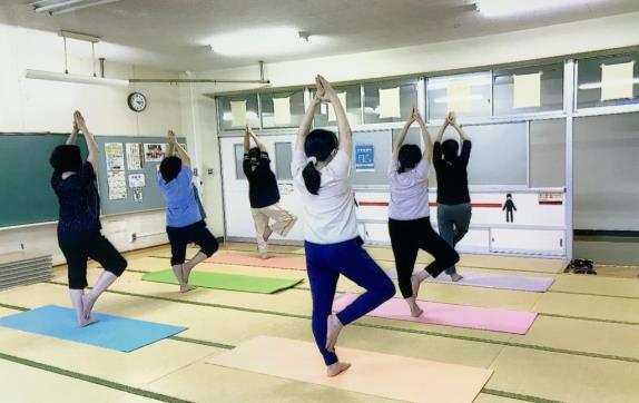 両手を伸ばして立ち、右膝をまげて横に開くポーズをしている6名の参加者の方々の写真