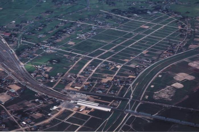駅周辺の広大な農地がいくつもの四角状に区切られている様子を上空から撮った写真