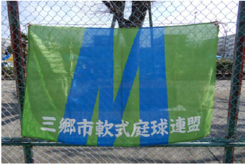 緑地に青で大きくMと書かれ下側に「三郷市軟式庭球連盟」と書かれた垂れ幕の写真