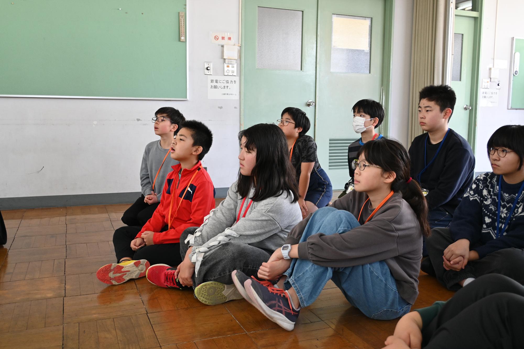 シェイクアウト訓練の説明を聞く参加者