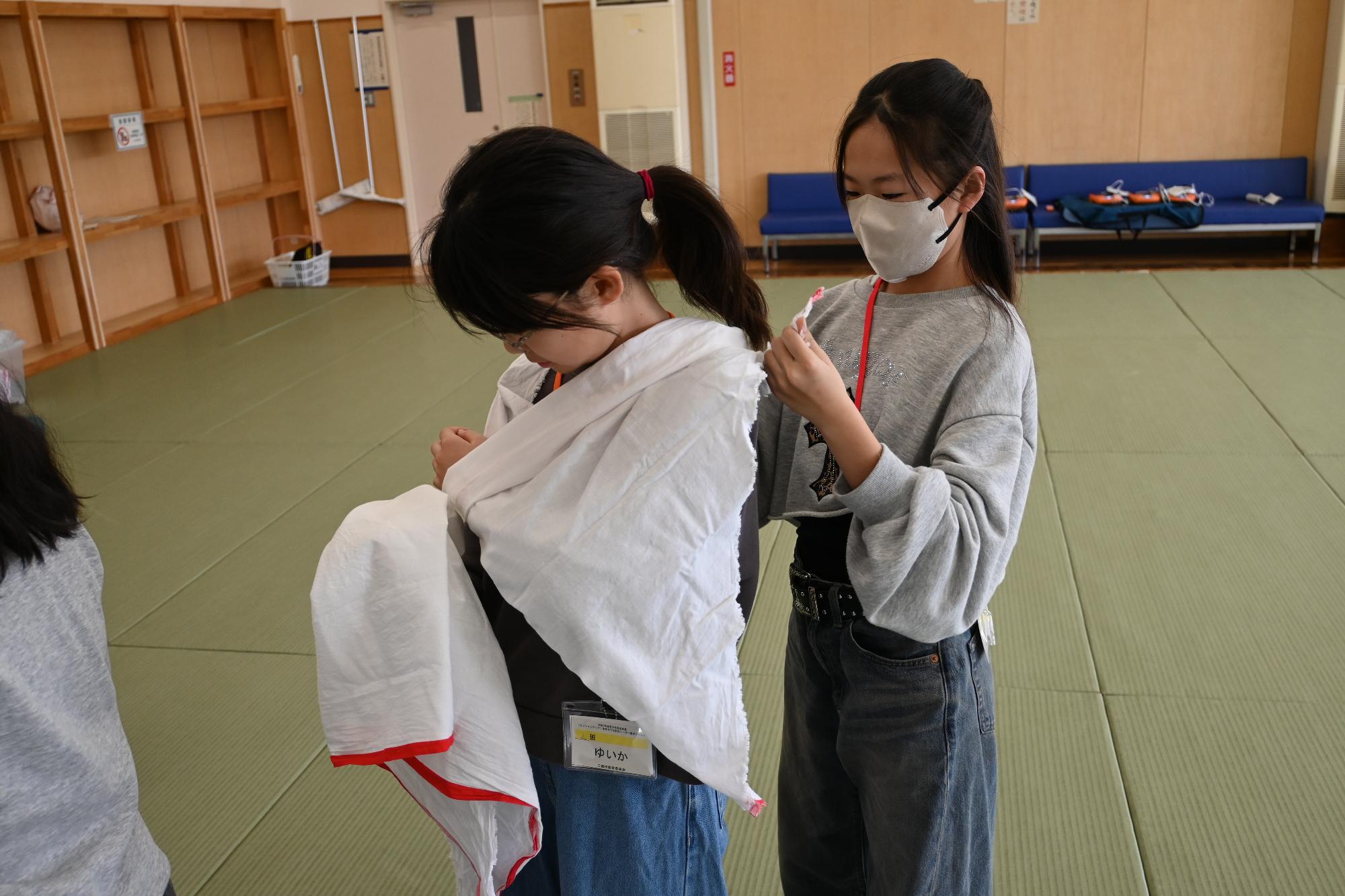 三角巾（腕のケガ）の練習をする参加者