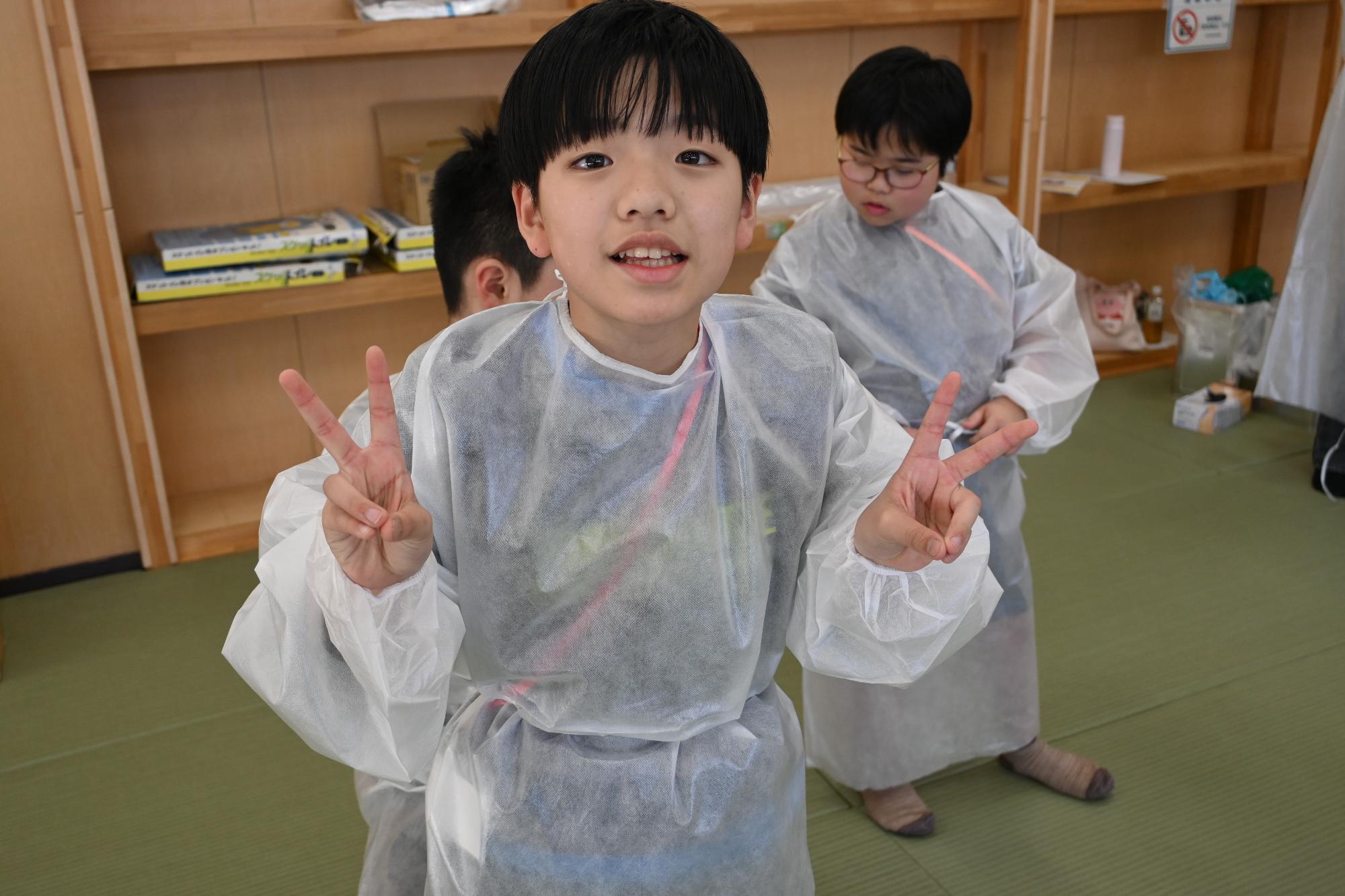 アイソレーションエプロンの着用体験をする参加者