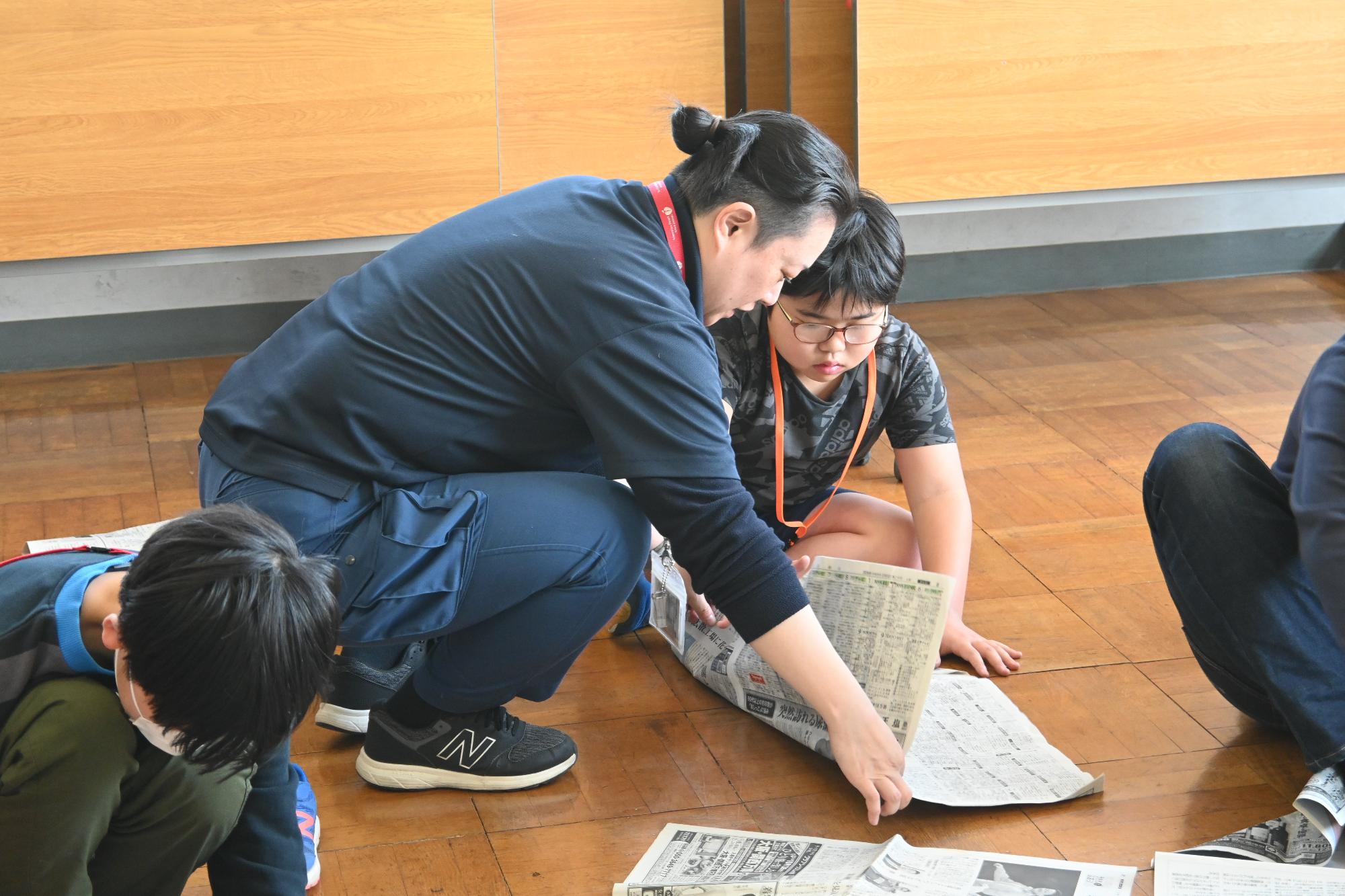 新聞紙スリッパを作る様子