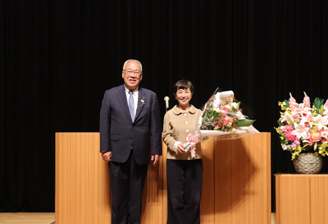 舞台上で木津市長と花束を手に持った阿川佐和子氏が並んで立ち記念撮影をしている写真