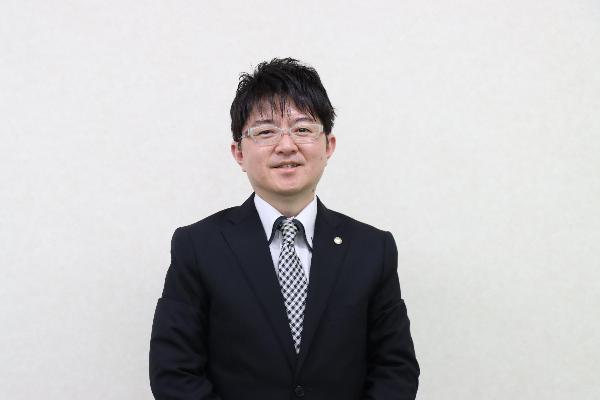 眼鏡をかけスーツを着た藤富郷様の写真
