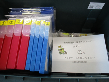 左側に赤と青のクリアケースが並び、右側に指示書が置いてある写真